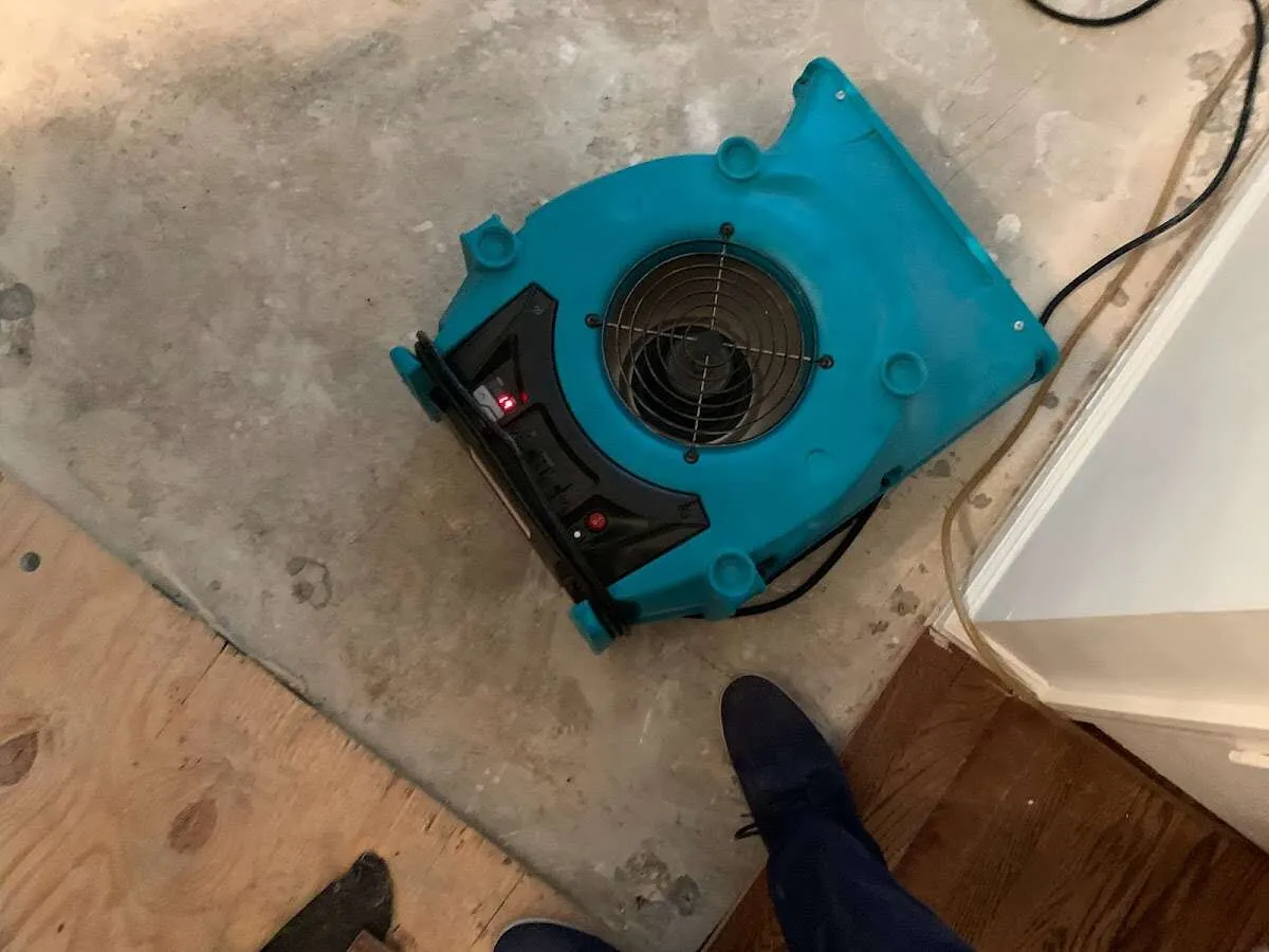 Air mover drying subfloor during Commercial Water Damage Restoration in West Dundee